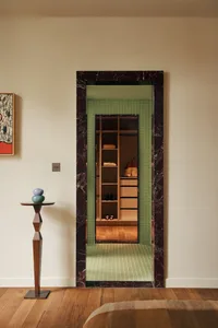Modern closet display with marble frame and green tile flooring