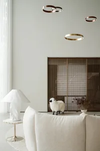 Modern minimalist living room featuring a white sofa, a white table lamp, and a metal decorative wall panel.
