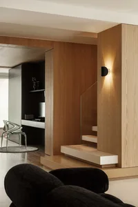 Minimalist living room featuring wood elements and understated lighting.