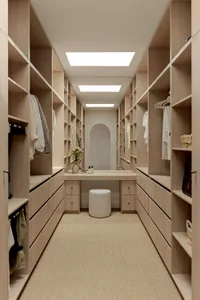 A well-organized, minimalist closet with wooden shelves and a vanity area with a stool and flowers.