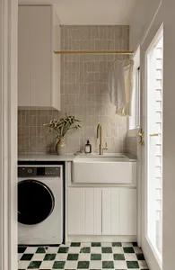 A minimalist laundry room featuring ceramic tiles on the walls and green and white checkered tiles on the floor.