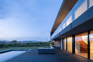 Modern minimalist residential deck with a view, featuring a wooden deck and a white sofa.