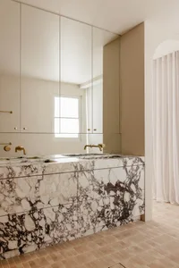 Modern bathroom featuring marble finishes and brass fixtures.