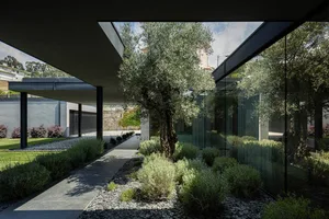 Modern house exterior featuring glass walls and concrete structures.