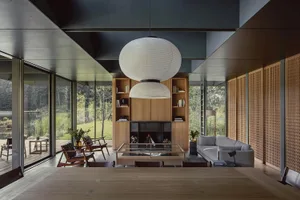 Modern interior design featuring a living room with wood finishes, a glass coffee table, and a fireplace.