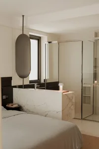 Modern bathroom with marble countertops and glass walk-in shower.