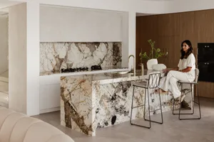 A modern residential kitchen featuring a luxurious marble countertop and backsplash.