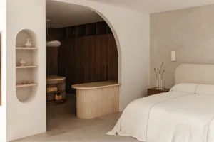 Minimalist bedroom with a large bed, wooden headboard, and built-in shelves.