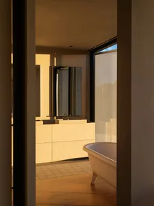 Modern bathroom featuring wooden floor, tiled walls, and concrete elements.