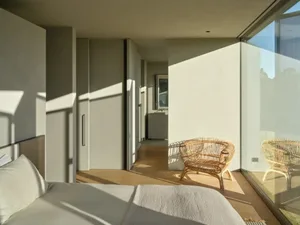 Modern bedroom featuring wooden flooring and minimalist design.