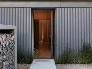 A modern residential entryway featuring corrugated metal walls.