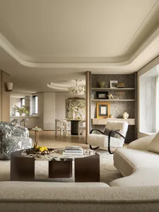 A modern living room featuring a combination of beige, white, and neutral tones, with a comfortable seating arrangement, roun