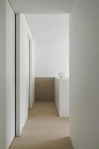 Modern minimalist corridor featuring warm wooden floorboards, contrasting sleek glass panels, and minimalistic lighting fixtu
