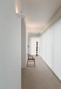 Modern minimalist design with wooden flooring and glass walls in a residential suite.