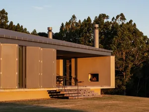 A modern residential exterior featuring concrete, glass, and steel materials.