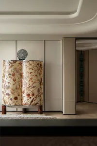A fabric curtain in a living room with a pattern of wildflowers.