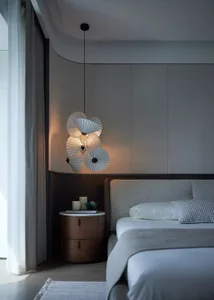 A minimalist bedroom with a textured gray headboard, elegant floor lamp, and soft lighting