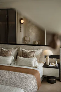 A modern bedroom featuring patterned fabrics and a cozy ambiance.