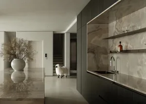 Modern kitchen featuring marble countertops and backsplash, with a large vase of flowers and a sheep figurine.