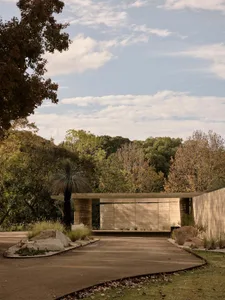 Modern, minimalist exterior with concrete walls and a wooden canopy.
