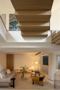 A modern living room featuring wooden shelving, a round coffee table, and a cozy seating arrangement.