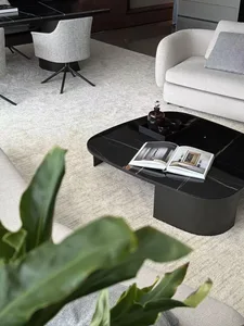 Modern living room with a black marble coffee table, white couch, and grey chairs.