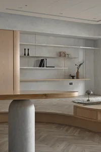 A modern minimalist living room featuring a wooden coffee table and floating shelves.