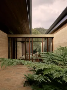 A modern residential entry with concrete walls and a glass door.