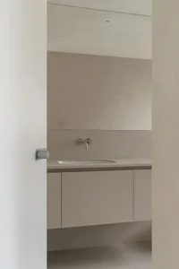 Modern minimalist bathroom with a concrete countertop and sink, no visible clutter or decorations.