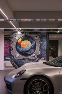 A futuristic metallic garage with a space-themed mural on the wall.