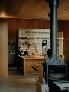 A modern kitchen with wooden elements and a family cooking together under a wooden ceiling.