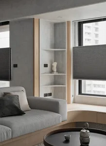 Modern minimalist living room featuring gray fabrics, concrete walls, wooden accents, and metal elements.