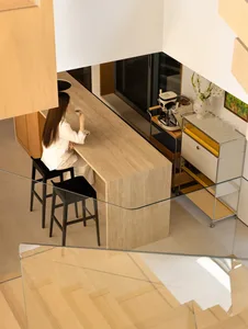 A modern residential kitchen featuring wooden cabinetry, stone countertops, and metal accents.
