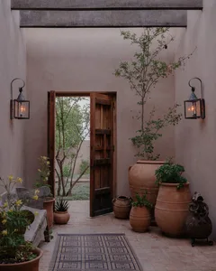 A rustic entryway features terracotta vases and pots, creating a warm and welcoming atmosphere.