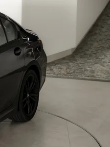 A modern black car parked in a concrete interior