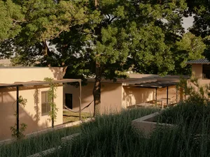 A modern architectural design featuring sandstone walls and a spacious, open layout.