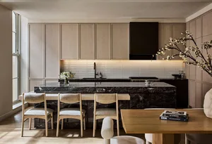 A minimalist residential kitchen featuring marble countertops and white cabinetry.