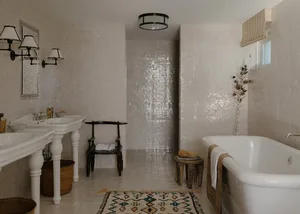 A modern bathroom with white tiles, a white bathtub, and decorative elements.