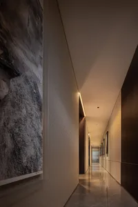 An elegant, metallic modern interior with a long, illuminated corridor.