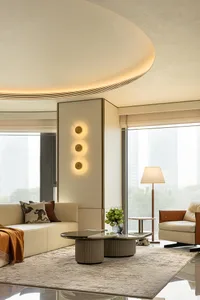 A modern living room with neutral-toned leather and cotton furniture, large windows, and round coffee tables.
