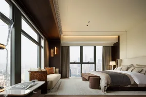 Modern residential bedroom featuring soft textiles, wood accents, and glass elements.