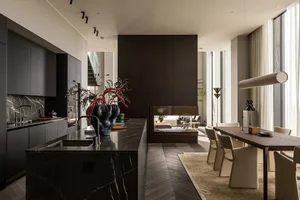 A modern residential kitchen with dark cabinets, a marble countertop, and a central island.