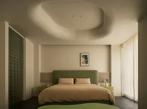 A minimalist bedroom with a green fabric headboard and a glass window