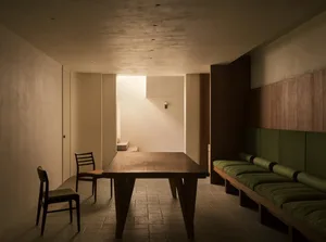 Modern dining room featuring a wooden table and chairs, with wooden walls and flooring.