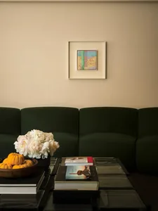 Modern interior design featuring green couches and decorative elements.
