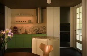 Contemporary residential kitchen featuring marble countertops, stainless steel appliances, and wooden furniture.