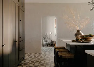 A modern kitchen featuring a tile countertop, marble floor with geometric pattern, and dark cabinetry.