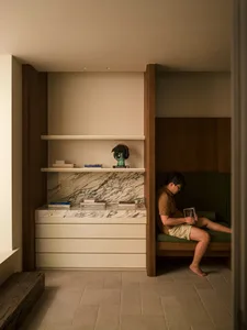 A reading nook with a modern marble and concrete design, featuring a person sitting and reading.
