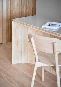 A home office featuring a minimalist design with wooden accents and a sleek, modern aesthetic.