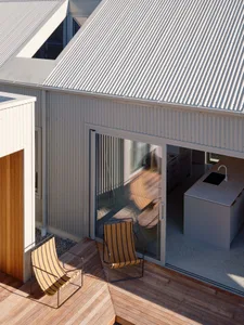 Modern residential deck featuring wooden flooring and outdoor furniture.